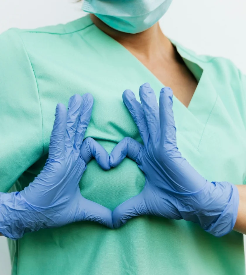 Doctor with hand shaped heart over chest